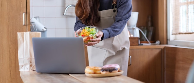 Kobieta blogerka wideo gotująca jedzenie w kuchni i filmująca koncepcję lekcji gotowania online