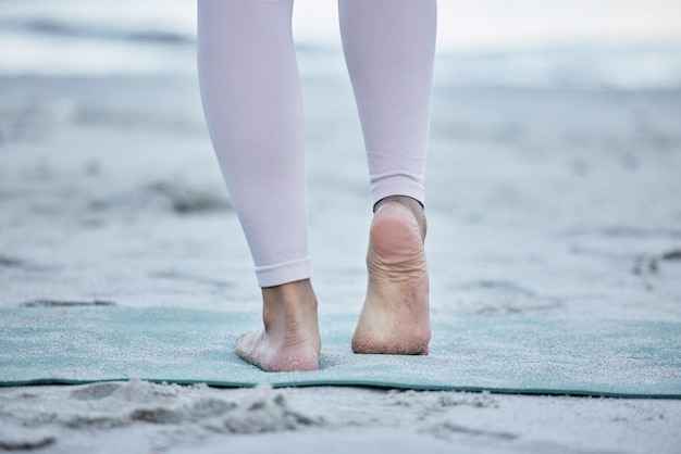 Kobieta boso i ćwiczenia jogi na plaży i rozciąganie kostki na piasku dla energii zen zdrowego stylu życia lub dobrego samopoczucia ciała Zbliżenie stopy i fitness na oceanie dla równowagi i treningu pilates