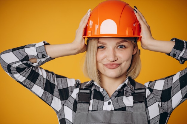 Zdjęcie kobieta budowniczy w pomarańczowym kasku na białym tle na pomarańczowym tle
