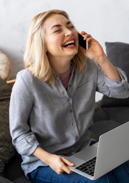 Kobieta buźka śmiejąc się podczas rozmowy przez telefon