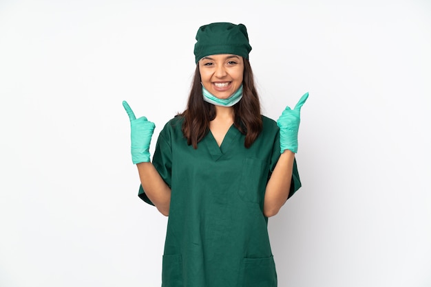 Kobieta chirurg w zielony mundur na białym tle na białej ścianie, wskazując na świetny pomysł
