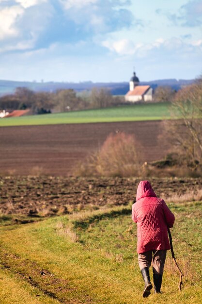 Kobieta chodząca po ścieżce na świeżym powietrzu, praktyka wędrówek dla relaksu i zachowania zdrowia