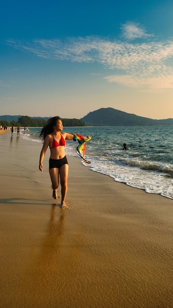 Zdjęcie kobieta chodzi po plaży z latawcem w ręku.