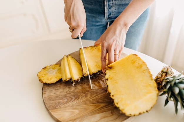 Kobieta cięcia świeżego ananasa na desce