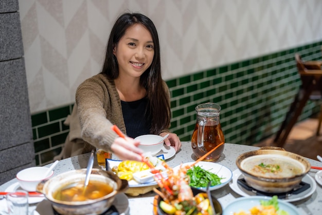 Kobieta cieszy się kolacją w chińskiej restauracji.
