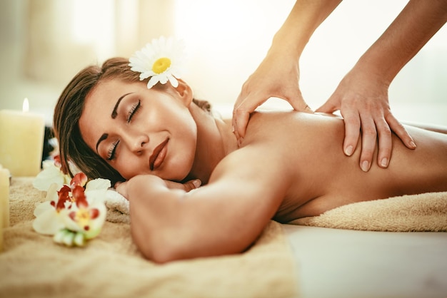 Kobieta cieszy się podczas masażu pleców w spa.