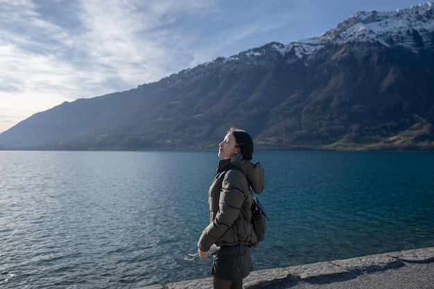 Kobieta cieszy się widokiem na góry i jezioro w Iseltwald nad jeziorem Brienz w Szwajcarii