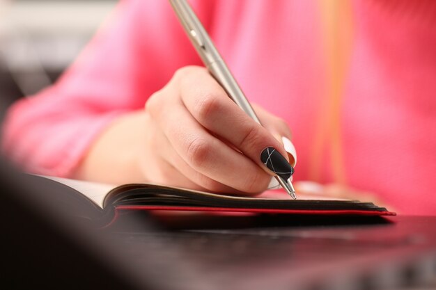 Kobieta ciężko się uczy, zapisuje informacje do notatnika