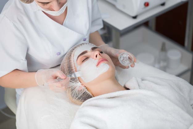 Kobieta coraz pielęgnacja twarzy przez kosmetyczkę w salonie spa