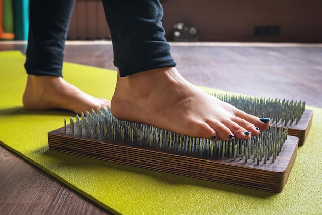 kobieta ćwicząca kroki jogi na desce sadhu z paznokciami, koncepcja na temat zdrowego stylu życia