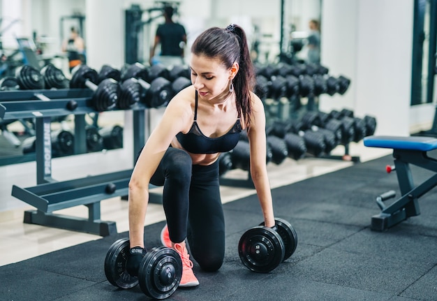 Kobieta ćwiczenia Z Mięśni Hantle Na Siłowni. Pojęcie Sportu, Fitness I Zdrowego Stylu życia.