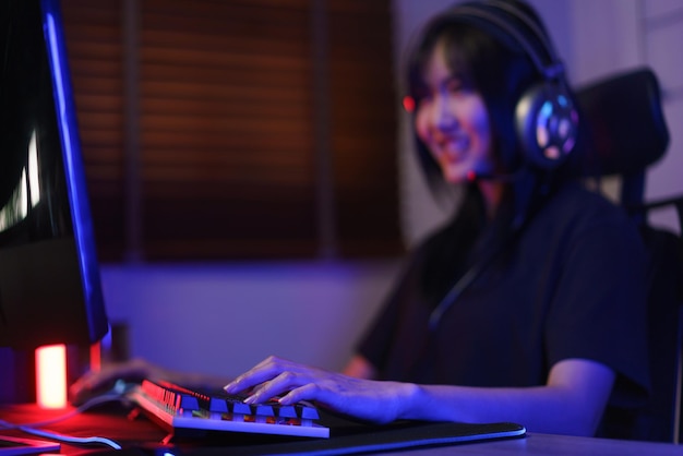 Kobieta cyber-hakerka w słuchawkach poważnie podchodzi do grania w gry lub hakowania systemu programowania