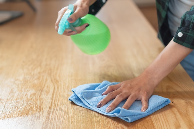 kobieta czyszczenia kuchni za pomocą sprayu do czyszczenia i szmatką.
