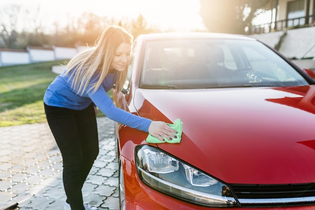 Kobieta czyszczenia samochodu ściereczką z mikrofibry, koncepcja car detailing (lub valeting).