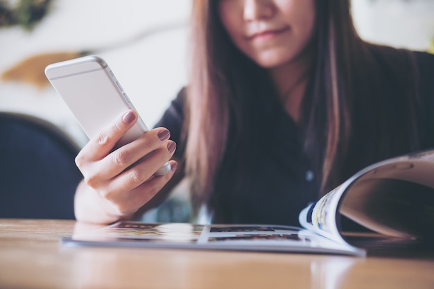 Kobieta czyta książkę i używa mądrze telefon