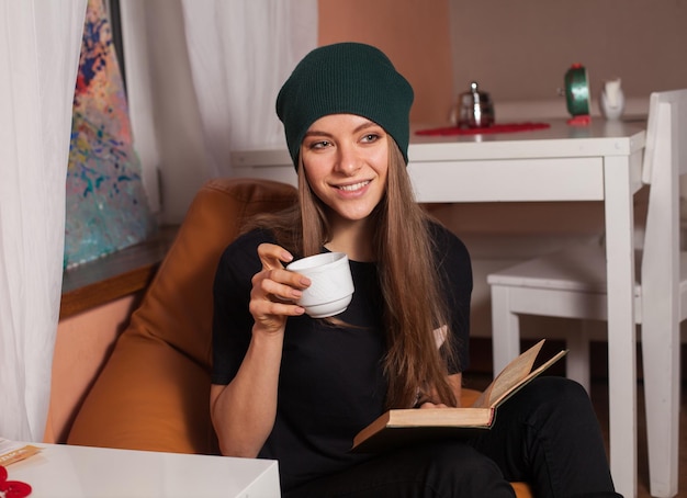 Kobieta czytająca książkę i pijąca herbatę w kawiarni