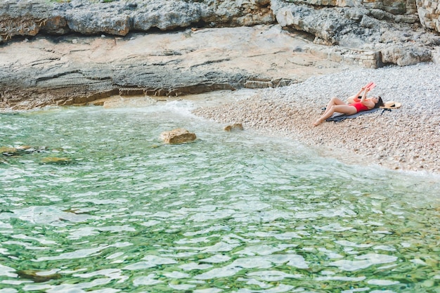 Kobieta czytająca książkę na plaży nad morzem wakacje