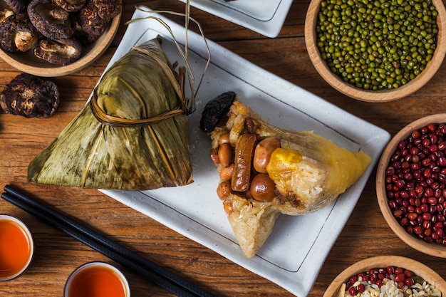 Kobieta daje innym zongzi (ryżowy kluska) jako prezent na Festiwalu Smoczych Łodzi