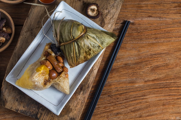Kobieta daje innym zongzi (ryżowy kluska) jako prezent na Festiwalu Smoczych Łodzi
