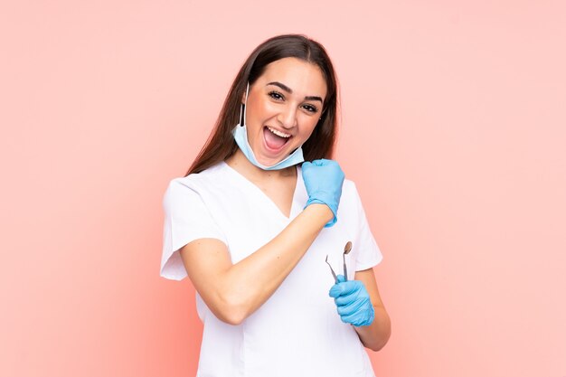 Kobieta dentysty mienia narzędzia na menchiach świętuje zwycięstwo