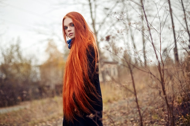 Kobieta długie czerwone włosy chodzi jesienią na ulicy