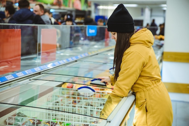 Kobieta dostaje produkty z lodówki w supermarkecie