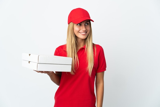 Kobieta dostawy pizzy trzyma pizzę na białym myśli pomysł, patrząc w górę