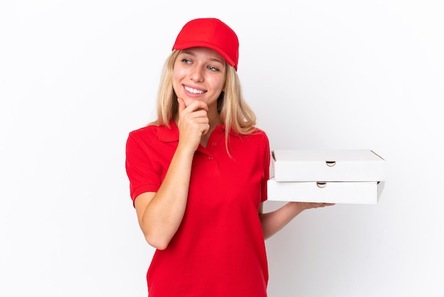 Kobieta dostawy trzymająca pizze na białym tle patrząc w bok i uśmiechnięta