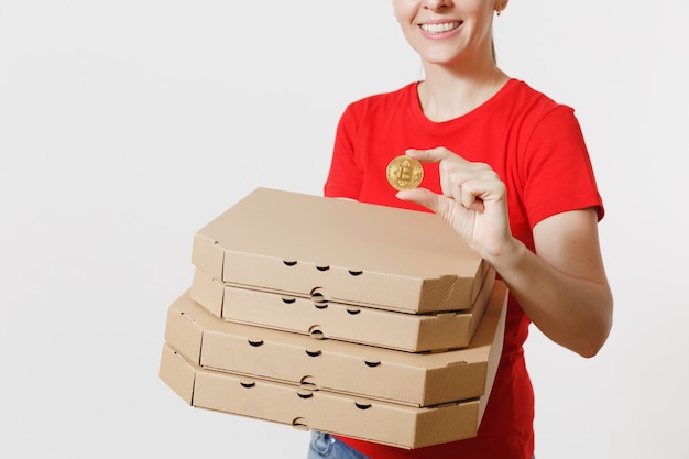 Kobieta dostawy w czerwonej czapce, t-shirt, dając zamówienie włoskiej pizzy jedzenie w pudełkach kartonowych flatbox na białym tle. Kobieta pizzy, pracująca jako kurier, trzymająca bitcoin, moneta złotego koloru.