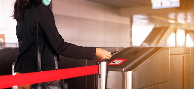 Kobieta dotykająca karty pasażera do drzwi automatycznych na dworcu kolejowym Koncepcja transportu