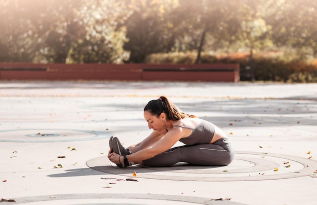 Kobieta fitness robi ćwiczenia jogi rozciągające się w letnim parku Sport Zdrowa koncepcja