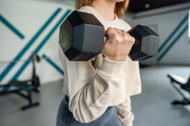 Kobieta fitness w treningu z dużymi hantlami do uprawiania sportu