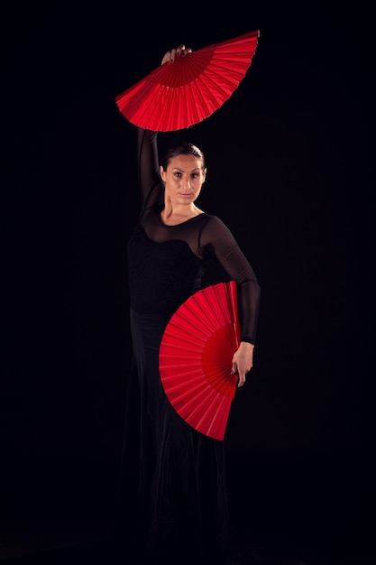 Kobieta flamenco w czarnej sukience i wachlarze tańczą