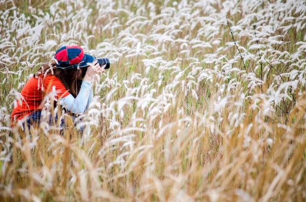 Zdjęcie kobieta fotograf fotografuje kwiaty.