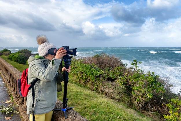 Kobieta fotograf pracuje podczas burzy w Biarritz Francja