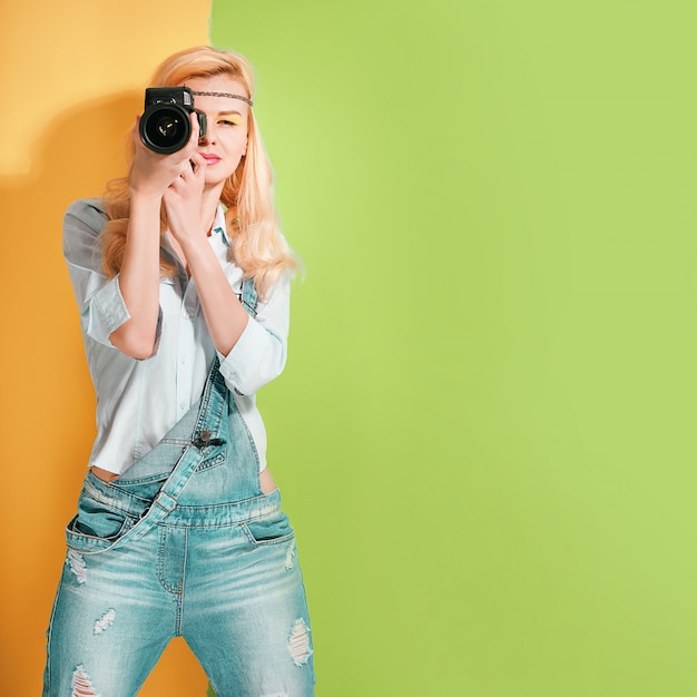 Kobieta fotograf robi strzałom na jaskrawej kolor powierzchni w słoneczny dzień