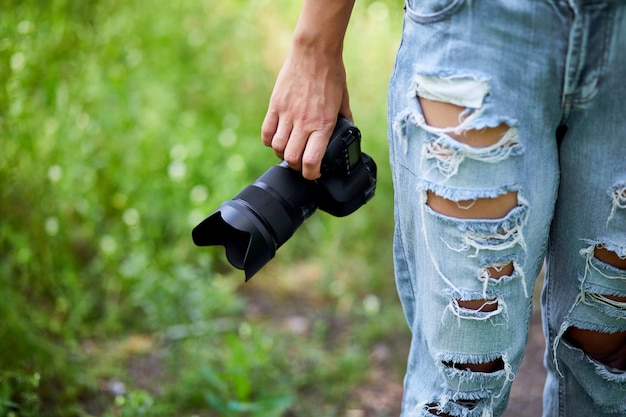 Kobieta fotograf z aparatem fotograficznym w ręku na zewnątrz