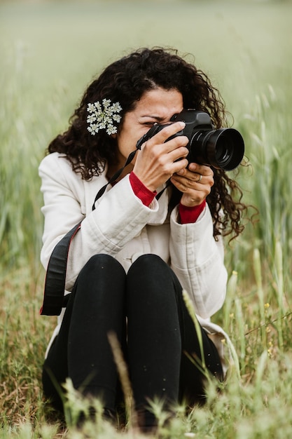 Kobieta fotografująca przez kamerę na polu