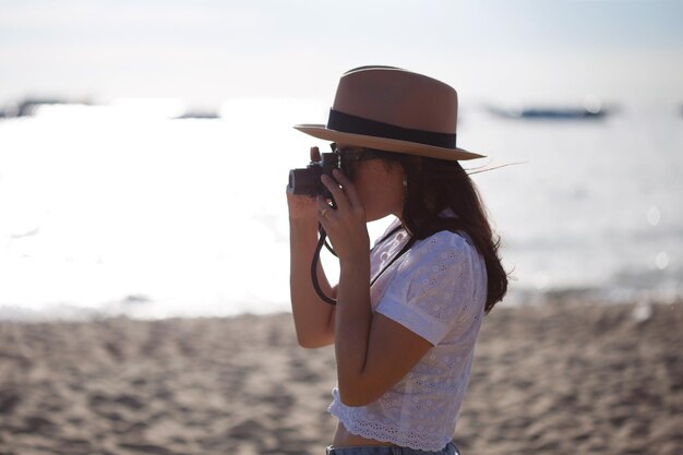 Zdjęcie kobieta fotografująca przy morzu