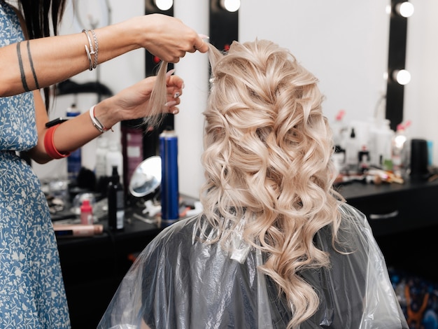 Kobieta Fryzjerka Robi Odświętną Fryzurę Dla Blondynki W Salonie Piękności