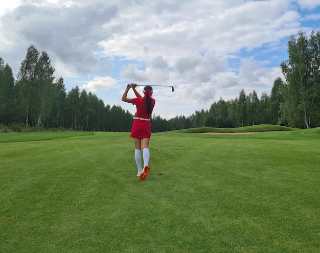 Zdjęcie kobieta golfista robi uderzenie huśtawką na polu golfowym