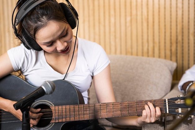 Kobieta gra na gitarze w stacji radiowej