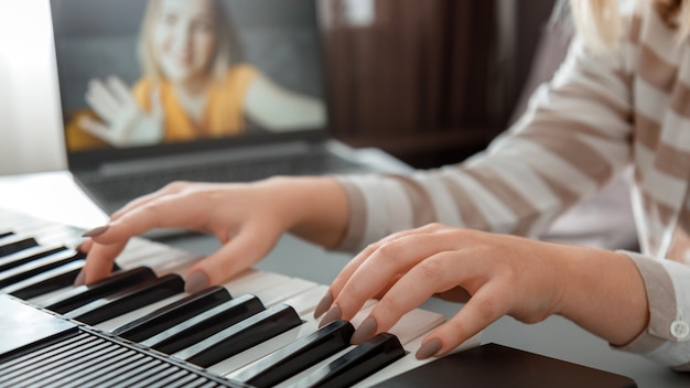 Kobieta Gra Na Pianinie Podczas Rozmowy Wideo Za Pośrednictwem Laptopa. Kobiece Ręce Muzyk Pianista Poprawia Umiejętności Gry Na Fortepianie Zajęcia Online Z Nauczycielem. Edukacja Muzyczna Online. Długi Baner Internetowy.