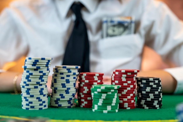 Kobieta gracz liczy żetony i podnosi zakład podczas gry w pokera w dolarach kasynowych w kieszeni koszuli poker koncepcja hazardu na białym tle