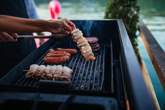 Kobieta grilluje pyszny składnik na grillu na świeżym powietrzu