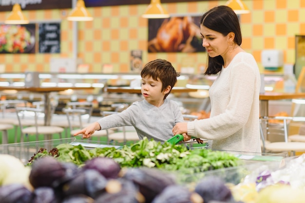 Kobieta I Chłopiec Dziecko Podczas Rodzinnych Zakupów Z Wózkiem W Supermarkecie