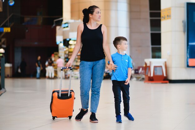 Kobieta i jej dziecko przechodzą przez terminal lotniska