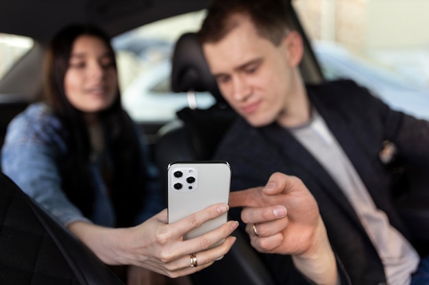 Zdjęcie kobieta i kierowca patrzący na telefon