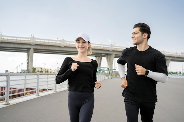 Kobieta i mężczyzna biegają uprawiając fitness na ulicy