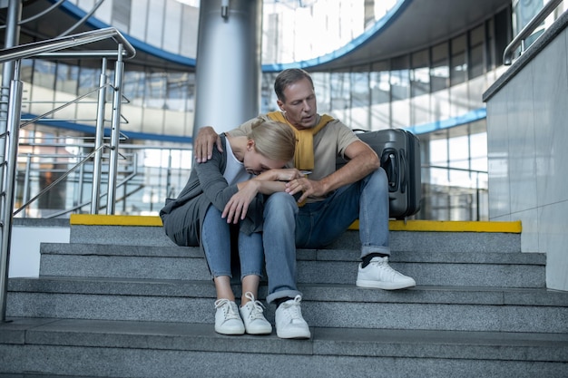 Kobieta i mężczyzna siedzący na schodach w terminalu